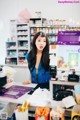 A woman standing behind a counter in a store.