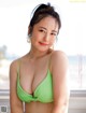 A woman in a green bikini posing for a picture.