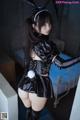 A woman in a black bunny costume posing for a picture.