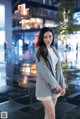 A woman standing in the middle of a city at night.