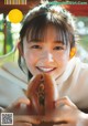 A young woman holding a hot dog in her hands.